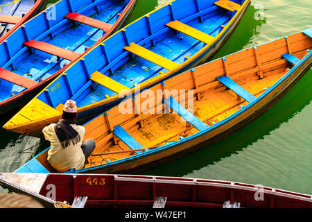 Pokhara, Nepal - November 21, 2015: der Mann, der in die bunten Boot am Phewa See in Pokhara sitzen. Stockfoto