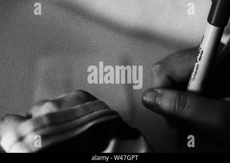 Person Schreiben und Zeichnen in Schwarz und Weiß mit Getreide Stockfoto