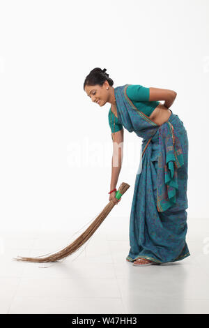 Frau fegt, und lächelnd Stockfoto