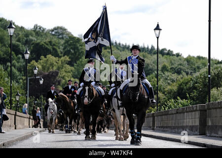 Kelso, Schottland - Juli 20: Kelso Civic Woche - yetholm Ride Out, Kelso. Kelso Laddie Mark Henderson trägt die Stadt Flagge zurück über Rennie Brücke, über die Rückkehr in die Stadt nach der Fahrt aus yetholm Samstag, 20. Juli 2019. Vor der 200 starke montiert Kavalkade mit RHM Sean Haken (2018 KL), Craig Logan (2017 KL). (Bild: Rob Grau): Rob Grau/Alamy leben Nachrichten Stockfoto