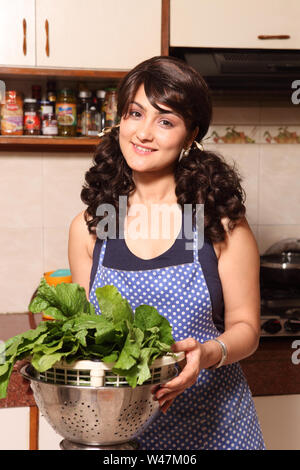 Frau in der Küche bereitet Gemüse Stockfoto