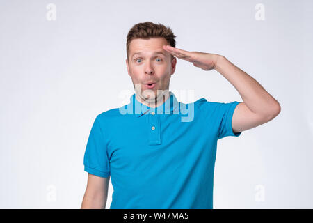 Schönen europäischen Mann im blauen Hemd salutierte Stockfoto