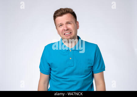 Weinenden jungen Mann im blauen T-Shirt an Kamera suchen, weinte, weil er seinen Job oder eine Freundin verloren. Stockfoto