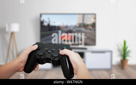 Jungen spielen auf großen TV im Wohnzimmer. Konzept der digitalen Unterhaltung, Spiele Industrie. Stockfoto