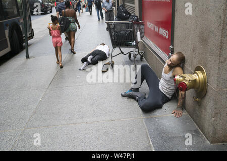 Zwei Männer, die sich an der West 32nd Street in Manhattan, wahrscheinlich aufgrund von Alkoholkonsum in New York City Stockfoto