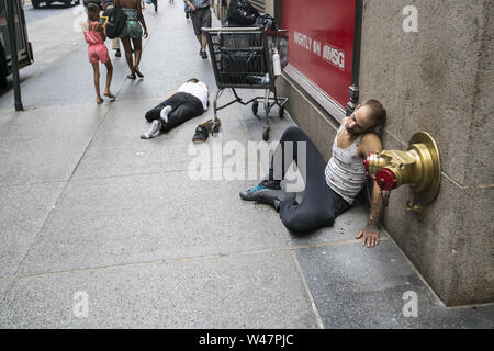 Zwei Männer, die sich an der West 32nd Street in Manhattan, wahrscheinlich aufgrund von Alkoholkonsum in New York City Stockfoto