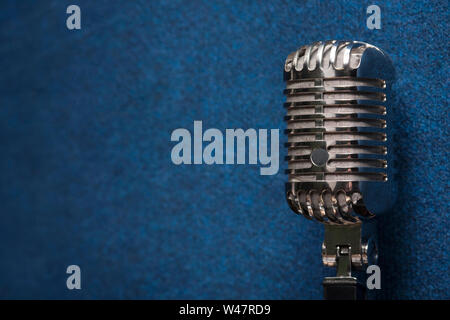 Eine professionelle glänzend Moderne dynamische Studio vocal Mikrofon auf einem eleganten dunklen Blau grunge vintage Hintergrund Textur. Gesang und Aufnahme Stockfoto