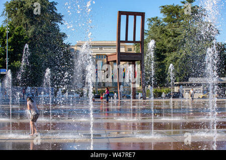 Kinder spielen im Wasser Brunnen auf der Place des Nations in Genf an einem heißen Sommertag. Genf. Schweiz Stockfoto