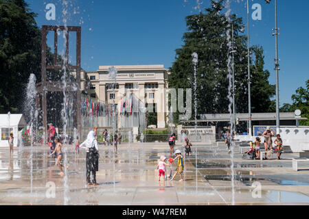 Kinder spielen im Wasser Brunnen auf der Place des Nations in Genf an einem heißen Sommertag. Genf. Schweiz Stockfoto