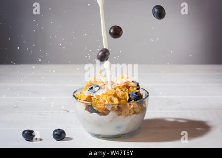 Mais Getreideflocken, Blaubeeren, und Milch Spritzen Stockfoto