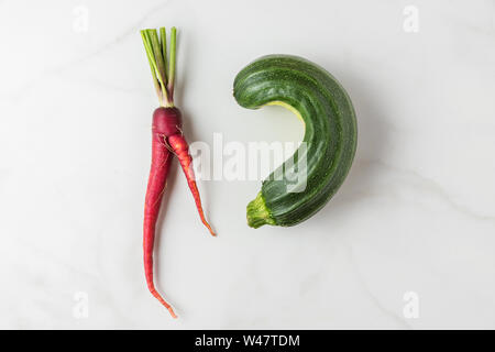 Trendy hässlich Bio Gemüse Karotten und Zucchini vom Haus Garten auf weißem Marmortisch. oben flach Stockfoto