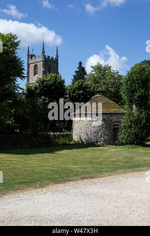 Alte runden Stein Taubenschlag mit konischem Dach neben St. James Kirche und Avebury Manor in Wiltshire, England. Stockfoto