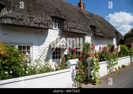 Eine typische weiß getünchten und strohgedeckten English Country Cottage mit traditionellen englischen Blumen in Avebury, Wiltshire bereit. Stockfoto
