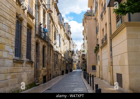 Bordeaux, Frankreich - 5. Mai 2019: Mannequin einer schwarzen Katze und ein Mann auf dem Balkon eines Wohnhauses im historischen Zentrum von Bordeaux, Frankreich Stockfoto