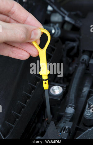 Der Ölstand mit dem Messstab in einem Auto Motor. Stockfoto