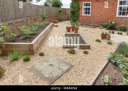 Eiche sleeper angehobenen Betten in einem Innenhof und Garten Design mit harten landscpaing, Kies und Terracotta Töpfen Stockfoto