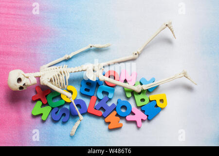 Skelett Modell auf bunte Buchstaben auf einem farbigen Hintergrund Stockfoto