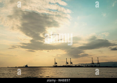 Osaka Hafen mit Kran Silhouette bei Sonnenuntergang. Japan. Stockfoto