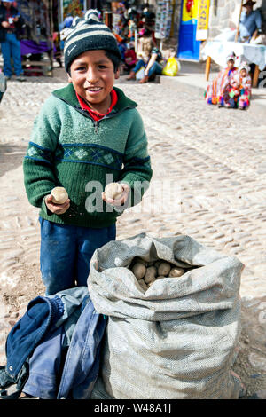 PISAC, PERU - April 30, 2012: Ein kleiner Junge steht neben einen Sack Kartoffeln, die er auf dem Markt ist der Verkauf an Pisca im Heiligen Tal der Inkas in Stockfoto