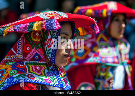 Eine Dame in der Peruanischen Kostüm gekleidet wartet an der Plaza de Armas in Cusco in Peru während der May Day Parade durchführen. Stockfoto