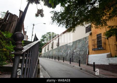 Alte Häuser, Vegetation, belaubten Bäume, einsame Gasse und altes Eisen Geländer mit Ornament und ein bisschen Rost El Hatillo Miranda Staat Caracas Venezu Stockfoto