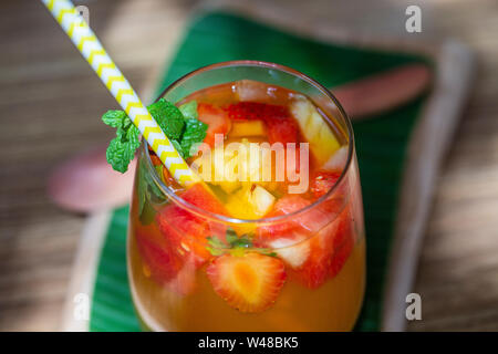 Frucht Limonade aus roten Erdbeeren, Melonen und Ananas in ein Glas. Close Up. Erfrischendes Getränk von Stück Obst Stockfoto