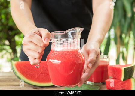 Wassermelone Smoothies und Wassermelone in Scheiben geschnitten auf hölzernen Tisch reif. Stockfoto