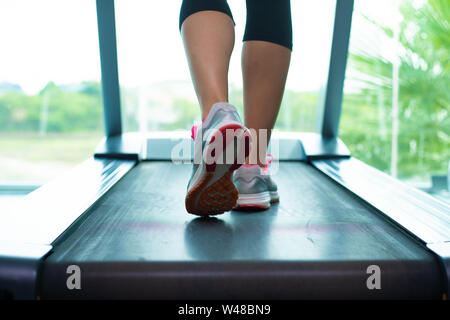 Close up womans Beine in rosa Sneakers auf Ein. Laufband im Fitnessstudio Stockfoto