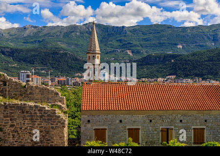 Blick auf die Altstadt von Budva aus der Zitadelle mit der Kirche der Heiligen Dreifaltigkeit und die Berge im Hintergrund in Montenegro, Balkan an einem sonnigen Tag Stockfoto