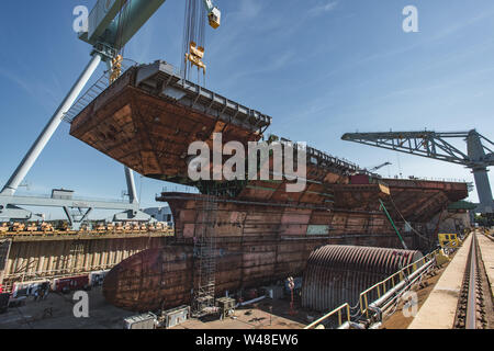 190710-N-N 2201-100 Newport News, Virginia (10. Juli 2019) Der obere Bogen Einheit der Zukunft Flugzeugträger USS John F. Kennedy (CVN 79) mit der primären Struktur des Schiffes angebracht ist, Juli 10, 2019, bei Huntington Ingalls Branchen Newport News Shipbuilding. John F. Kennedy ist die zweite Gerald R. Ford-Klasse Flugzeugträger und die zweite Flugzeugträger zu nach der 35. Präsident benannt werden. Die 1.096-Fuß-Rumpf ist länger als drei Fußballfelder und mehr als 3.000 Werften und 2.000 Lieferanten aus dem ganzen Land für den Bau des Schiffes. Die Taufe für John-F.-Ken Stockfoto