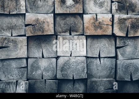 Gestapelte Holzbalkenenden Texturhintergrund, quadratisches Holzstamm-Muster mit sichtbaren Wachstumsringen, rustikaler Baustoffhintergrund für Architectu Stockfoto