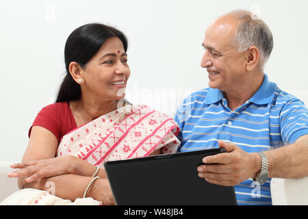 Indischer senior Mann mit Laptop mit seiner Frau Stockfoto