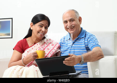 Älterer Mann, der mit seiner Frau einen Laptop benutzt Stockfoto