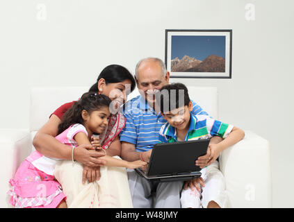 Familie mit Laptop und lächelnd Stockfoto