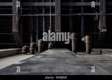 Schmutzige schwarze Rohre aus Beton Wand. Textur Hintergrund Grafik Asset. Stockfoto