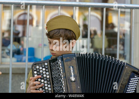 Moskau, Russland - Mai 9, 2019: Unsterbliche regiment Prozession in der Tag des Sieges, ein Soldat Kid spielen Akkordeon durch die künstliche Lagerfeuer Stockfoto