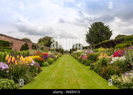 Doppel Blumenrabatten mit Fülle von blühenden Pflanzen in der Höhe des Sommers. Stockfoto