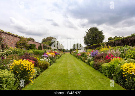 Doppel Blumenrabatten mit Fülle von blühenden Pflanzen in der Höhe des Sommers. Stockfoto