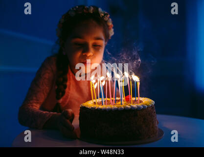 Geburtstag. Ein kleines süsses Mädchen bläst Kerzen auf den stoke Stockfoto