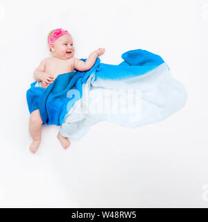 Blick von oben auf die niedlichen Baby Baby in einem hellblauen Schal wie Engel auf der Wolke gehüllt. Stockfoto