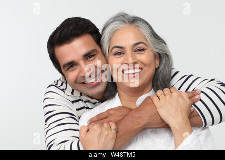 Mann umarmt seine Mutter von hinten Stockfoto