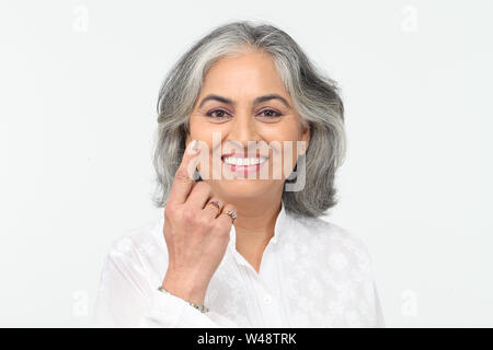 Portrait einer älteren Frau weisenden und lächelnd Stockfoto