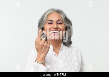 Portrait einer älteren Frau weisenden und lächelnd Stockfoto