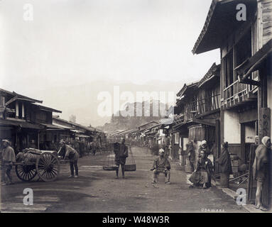 [ 1870s Japan - Japanese Street View of Odawara ] - Menschen drängen die Hauptstraße von Odawara, Präfektur Kanagawa. Odawara war eine Burgstadt und eine Poststation auf der Tokaido-Autobahn, die Edo (das heutige Tokio) mit Kyoto verband. 19th Jahrhundert alte Albumin-Fotografie, Baron Raimund von Stillfried. Stockfoto