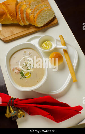 Suppe mit Brot in Tablett serviert Stockfoto