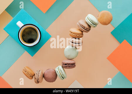 Macarons und Expresso, flach auf geometrische Papier Hintergrund legen Stockfoto