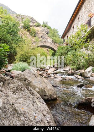 Creek und Brücke von einem Bug in der kleinen mittelalterlichen Stadt Tavascan, Pallars Sobira Region. Katalanischen Pyrenäen. Katalonien, Spanien. Stockfoto