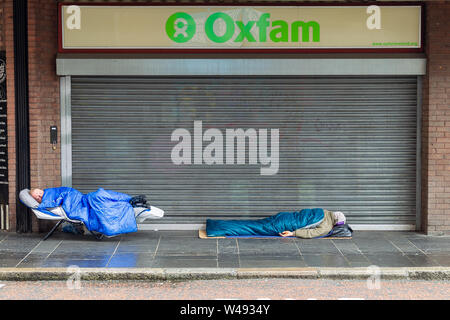 Die Castle Street Belfast, Antrim, Großbritannien 10/Juli/2019 Zwei obdachlose Männer außerhalb der Oxfam Shop in der Castle Street, Belfast Schlafen Stockfoto