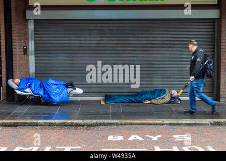 Die Castle Street Belfast, Antrim, Großbritannien 10/Juli/2019 Zwei obdachlose Männer außerhalb der Oxfam Shop in der Castle Street, Belfast Schlafen Stockfoto