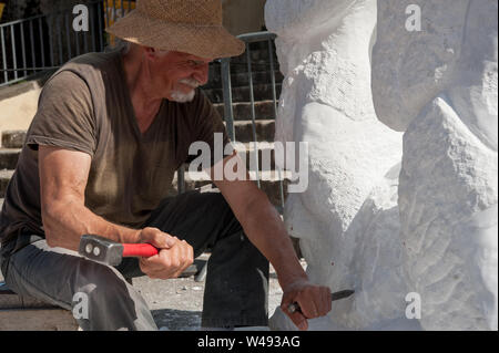 Senior Bildhauer arbeiten im Freien auf seinem Marmor Skulptur in seinem Workshop mit Hammer und Meißel Stockfoto